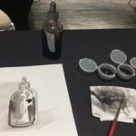 Ink Wash Painting Class demo setup with ink, brush, paper and water containers